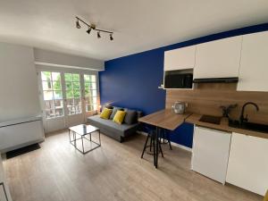 cocina y sala de estar con pared azul en Appartement avec balcon et vue sur port - wifi privé - au dessus du Restaurant le Yackams, en La Roche-Bernard