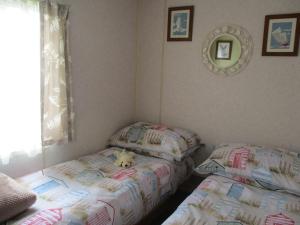 BactonにあるSummer Breeze Caravanのベッドルーム1室(ツインベッド2台、ベッドの上に動物の詰め物付)