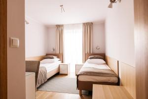 a hotel room with two beds and a window at Hotel Chata Za Wsią in Mysłakowice