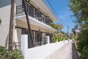 een wit gebouw met zwarte balkons in een straat bij Soula Apartments in Ýpsos