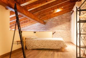 a bedroom with a bed and a brick wall at Marittimo Apartments in Valencia