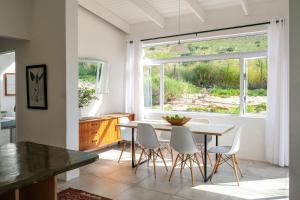 een keuken met een tafel en stoelen en een raam bij Kogman & Keisie Guest Farm in Montagu