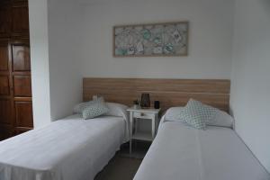 Łóżko lub łóżka w pokoju w obiekcie Hostal La Biela 43