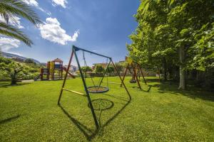 a group of swings in a park at Villa Dvori Viškovi in Podstrana