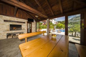 a wooden bench in a living room with a fireplace at Villa Dvori Viškovi in Podstrana +37 photos