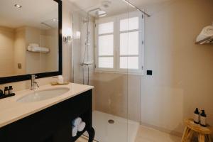 a bathroom with a sink and a shower with a window at Hôtel Des Gouverneurs in Bastia