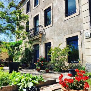 um edifício com flores em frente em La villa du chai em Lézignan-Corbières