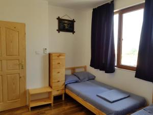 a small bedroom with a bed and a window at Guest House Antique in Sozopol
