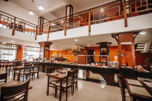 restauracja z drewnianymi stołami i krzesłami oraz bar w obiekcie Spazio Marine Hotel - Guaratuba w mieście Guaratuba
