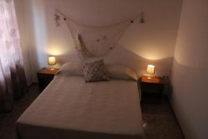 um pequeno quarto com uma cama com 2 candeeiros nas mesas em VillaRosa em Lotzorai