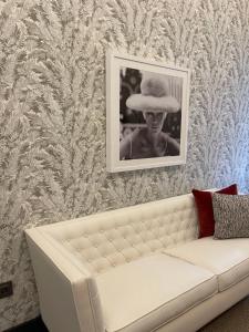 a white couch with a picture of a man in a hat at Soho Boutique Castillo de Santa Catalina - Adults Recommended in Málaga