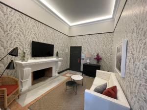 a living room with a fireplace and a tv at Soho Boutique Castillo de Santa Catalina - Adults Recommended in Málaga