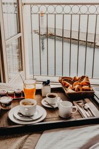 a table with a tray of pastries and cups of coffee at Hôtel Des Gouverneurs in Bastia