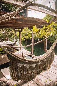 a hammock sitting on a wooden deck at Uman Glamping & Cenote Tulum in Tulum