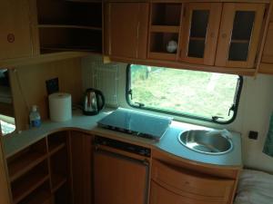 a kitchen in a caravan with a sink and a window at Zielony Port numer 3 in Władysławowo