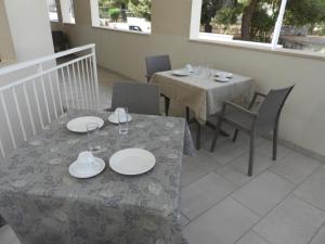 a dining room with two tables and chairs with plates on them at Sant'Ermete in Matino +50 photos
