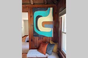 una sala de estar con sofá y una pintura en la pared en Peaceful Getaway Cottage on grounds of historic mid-century gem, en Northborough