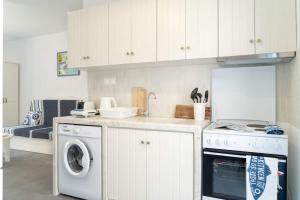 a kitchen with a washing machine and a washer and dryer at Blue Moon Apartments in Makry Gialos +2 photos