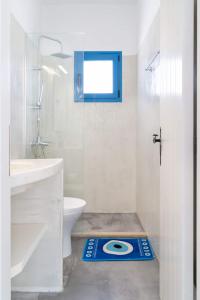 a bathroom with a toilet and a blue floor mat at Blue Moon Apartments in Makry Gialos