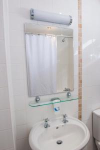 a bathroom with a sink and a mirror and a toilet at Old Colonial, Weston-Super-Mare by Marston's Inns in Weston-super-Mare