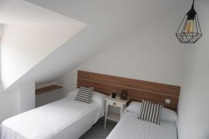 Łóżko lub łóżka w pokoju w obiekcie Hostal La Biela 43