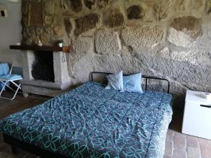 1 dormitorio con cama y pared de piedra en Casa nella roccia en Bomarzo