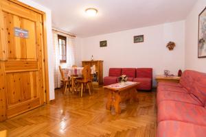ein Wohnzimmer mit einem roten Sofa und einem Tisch in der Unterkunft Lou Tsantelet in Cogne