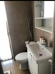 a bathroom with a white toilet and a sink at Apartamento Luminoso y cómodo in Seville