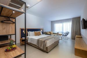Smy Kos Beach & Splash في ماستيخاري: غرفة نوم مع سرير وغرفة معيشة
