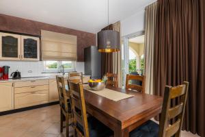 a kitchen with a wooden table and a dining room at Villa Vires in Labin