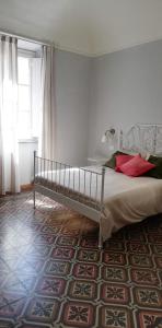 een slaapkamer met een bed en een groot raam bij Casa Ridolfi Holiday Home -Una terrazza sui giardini di Pisa in Pisa