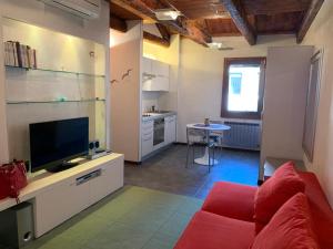 sala de estar con sofá rojo y TV en Tiepolo Charme Houses, en Venecia
