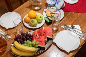 a wooden table with a plate of fruit on it at Hotel Zámeček Pod Hradem Starý Jičín 111 in Starý Jičín