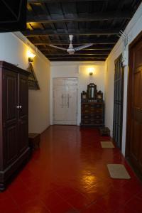 an empty living room with a ceiling fan and a door at Govindamangalam Homestay in Cochin