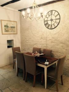 
a dining room table with a clock on it at Le Logis de Limalonges in Limalonges
