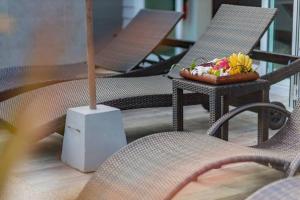 a table with chairs and a bowl of fruit on it at Honeybee Pool Villa Smooth as Silk in Ao Nang Beach