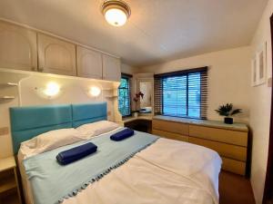 Schlafzimmer mit einem Bett mit blauem Kopfteil in der Unterkunft LUCY duży domek kempingowy - Nowy Kemping Camp Spot in Chałupy