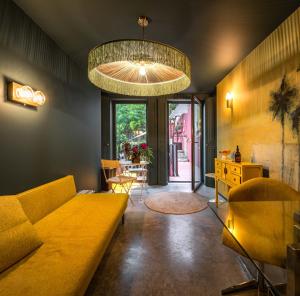 a living room with a yellow couch and a chandelier at toctoctoc lisboa in Lisbon