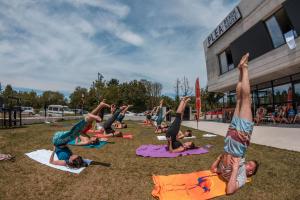 un grupo de personas haciendo yoga en la hierba en Plea Beach House, en Loredo