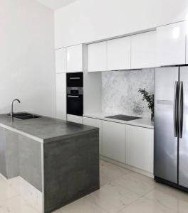 a kitchen with white cabinets and a stainless steel refrigerator at Apartment Beachfront Petar in Zadar