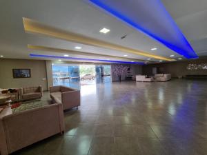 a large lobby with couches and a blue ceiling at Lacazzona Hotel in Belo Jardim