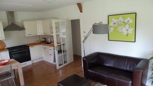 salon z kanapą i kuchnią w obiekcie Apartment ARDA w mieście Spijk