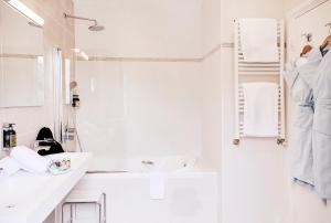 a white bathroom with a sink and a shower at Welcome Hotel in Villefranche-sur-Mer