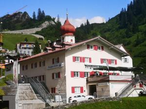 a large white building with a red roof at Hotel Berghaus Stuben in Stuben am Arlberg