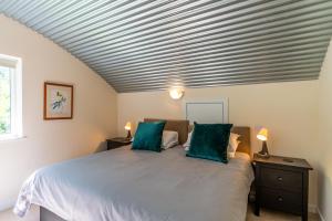 1 dormitorio con 1 cama grande con almohadas verdes en Ledge View en Chipping Campden