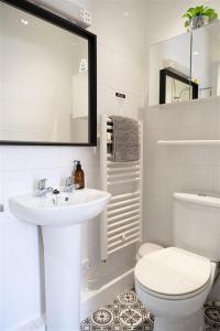uma casa de banho branca com um lavatório e um WC em Mory House em Bournemouth