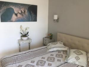 Clim Jardin et parking privé -piscine tennis et Park Vue mer في جراس: غرفة نوم بها سرير وصورة على الحائط +34 صورة