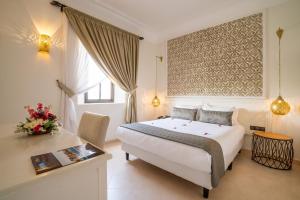 a hotel room with a bed and a desk at Marrakech Ryads Parc All inclusive in Marrakesh