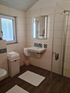 a bathroom with a sink and a mirror at Chalets am Badesee Lassing in Lassing +26 photos