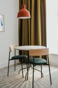 a table and two chairs and a lamp at Hotel Bries Den Haag - Scheveningen in The Hague